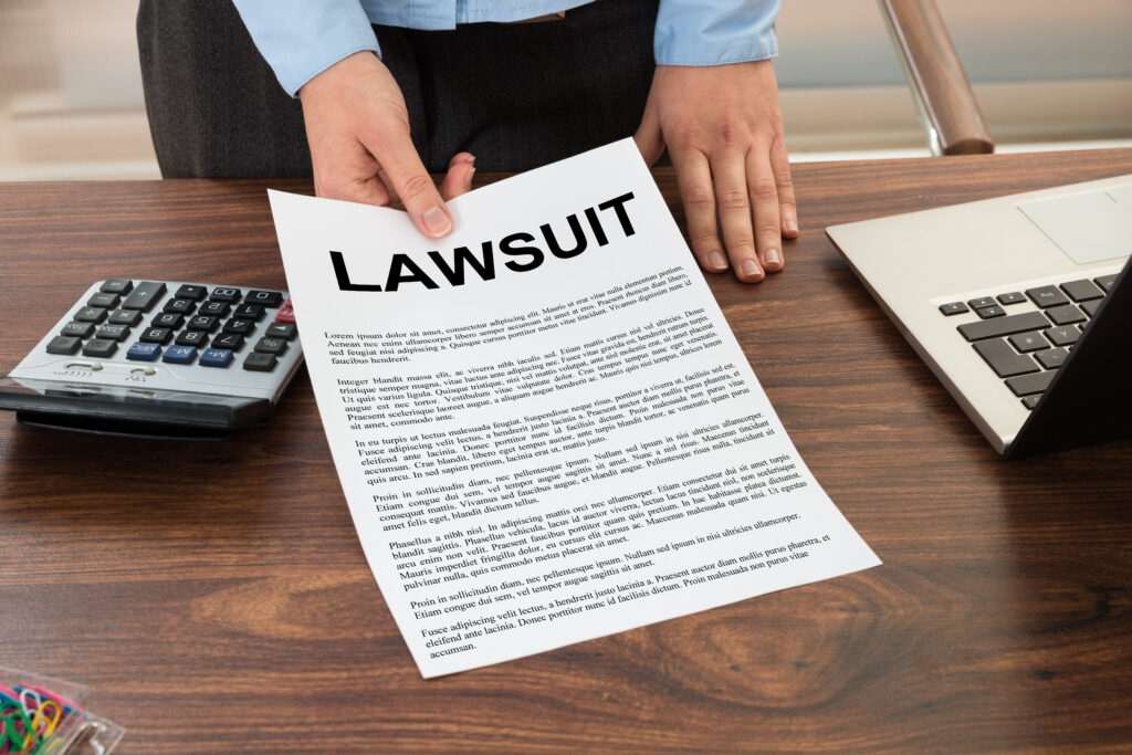 lawyer sliding lawsuit paper across office desk